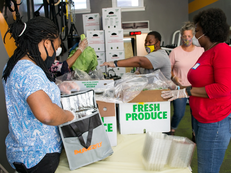Packing produce bags at Bourne2Fly Fitness in DC People packing produce into food bags at Bourne2Fly Fitness in Washington, DC